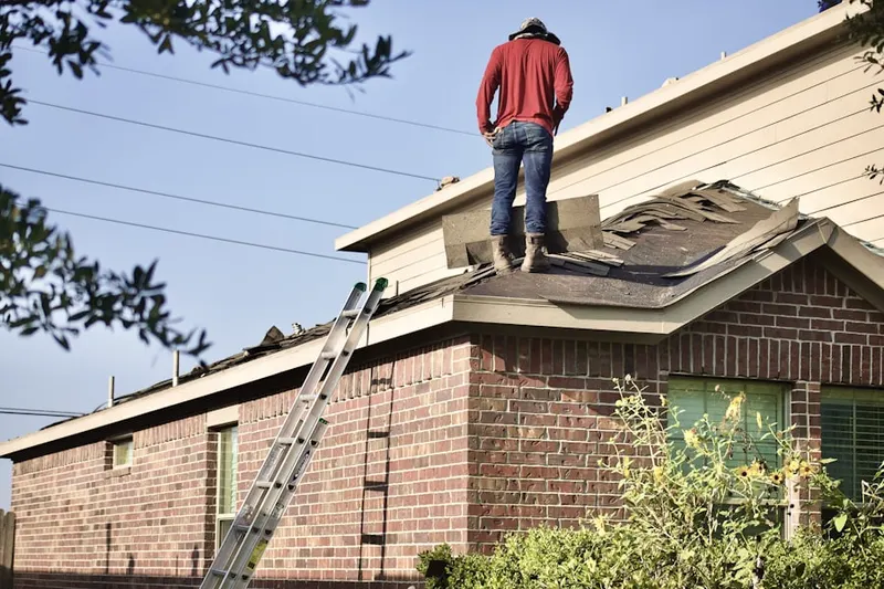Professional roofer working on a residential roof in Oxford Manor